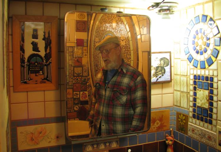 Pete Felten reflected in the mirror of the art bathroom