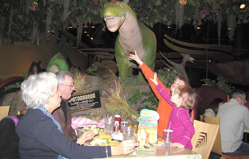 children reaching for an animatronic dinosaur